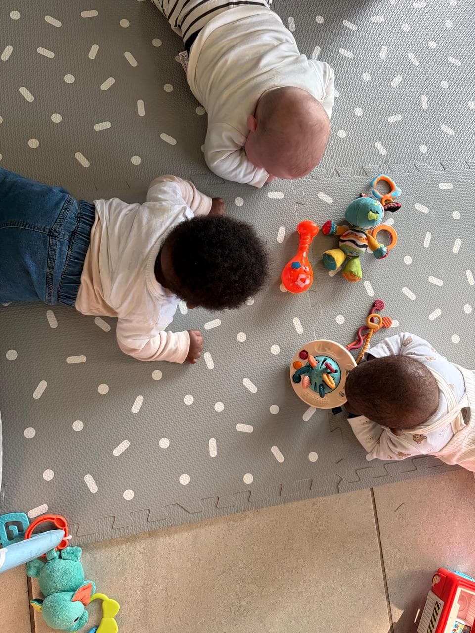 Babies playing together on a soft mat at the home