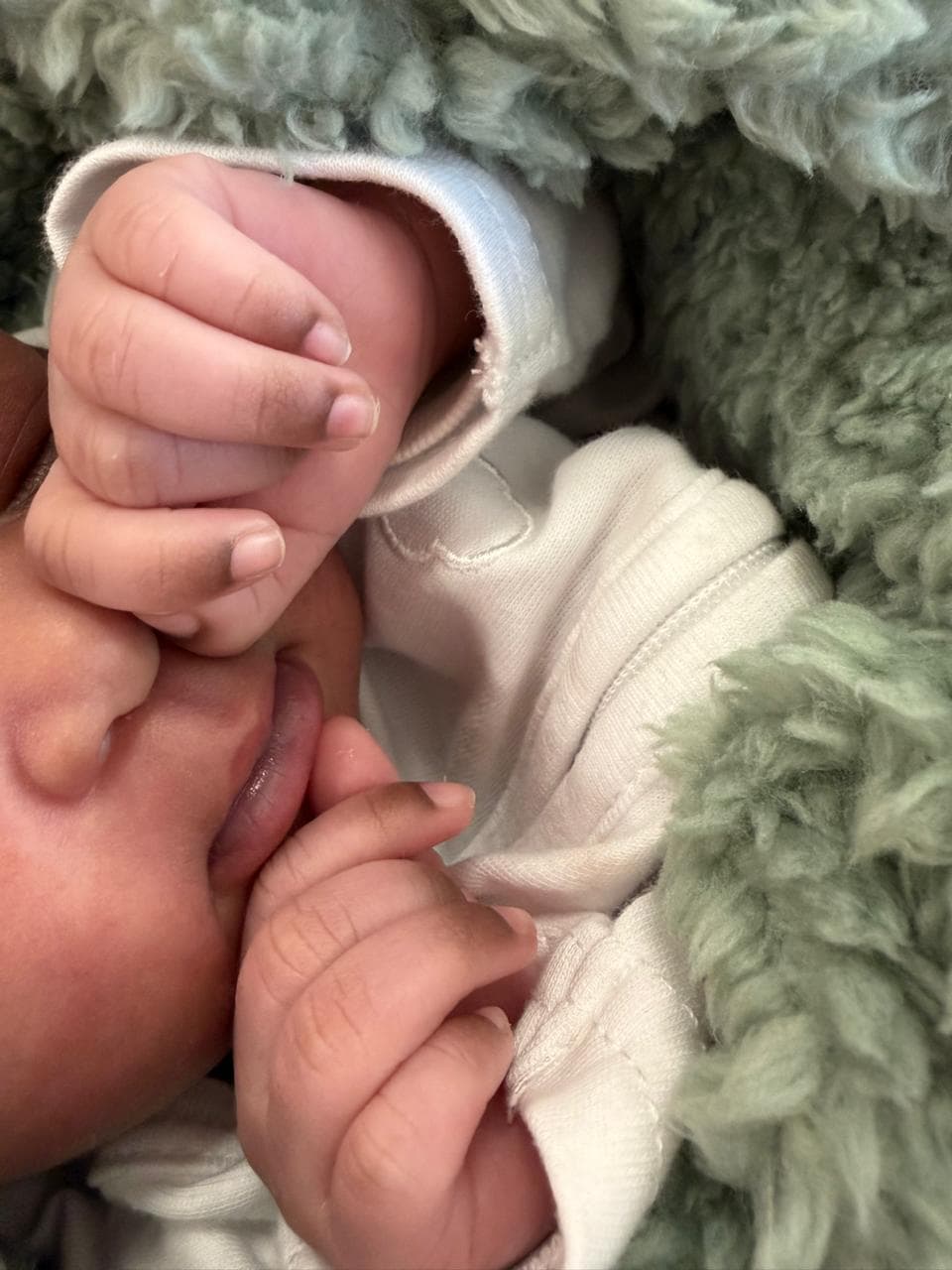 A sleeping baby swaddled in a soft blanket at New Life Baby House